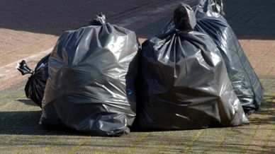 black trash bags in a suburban street