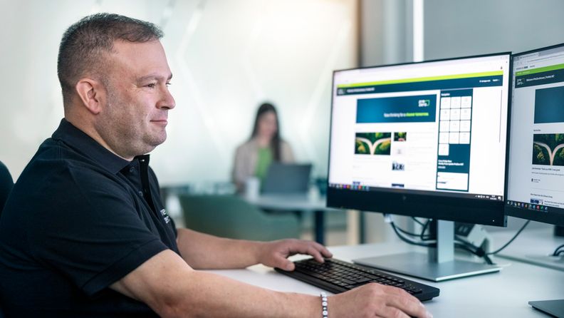PreZero-Mitarbeiter arbeitet konzentriert am PC im Büro.