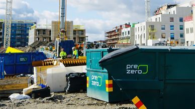 PreZero-containrar på byggplatsen, byggnationer i bakgrunden
