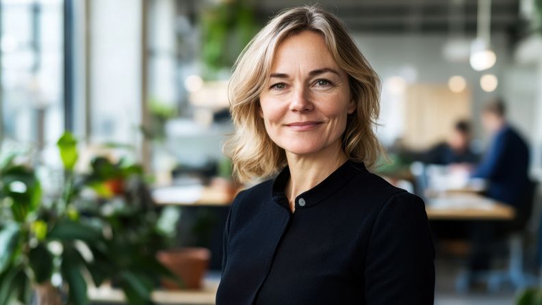 Kvinna på kontor som tittar in i kameran