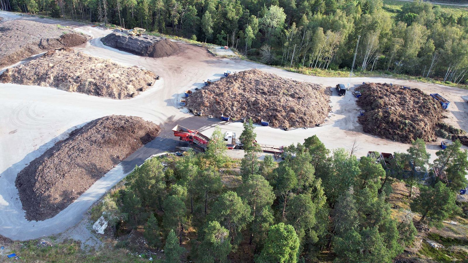 Bild uppifrån på jordhögar som processas till kompost