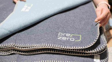 Mantas com logo PreZero, que resultaram do projeto de reciclagem do fardamento antigo da empresa - economia circular