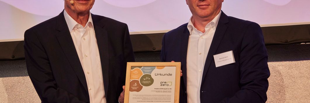 Prof. Dr. Michael Otto, Vorsitzender des Aufsichtsrats der Hamburger Handels- und Dienstleistungsgruppe Otto (links im Bild) und Dietmar Böhm, Vorstand PreZero Dual, Intragroup Services & New Business (rechts) halten bei der Auftaktveranstaltung der Allianz der Pioniere in Berlin die Gründerurkunde von PreZero in den Händen.