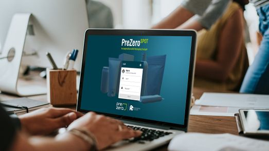 Zu sehen ist ein aufgeklappter Laptop auf einem Schreibtisch mit der Login-Seite der online-Anwendung SPOT