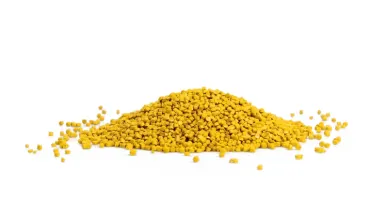 Pile of yellow plastic granules on a white background