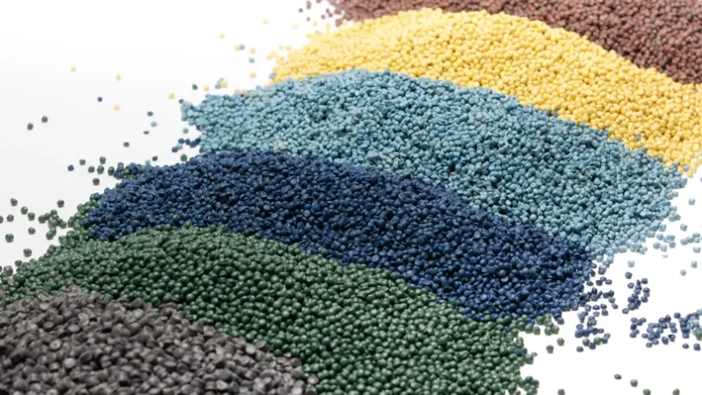 Color-sorted rHDPE plastic granules from PreZero in grey, green, blue, yellow, and brow