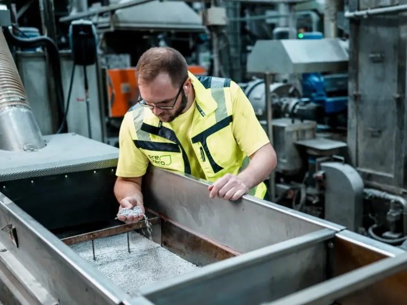 Qualitätssicherung im Kunststoffrecycling: PreZero Polymers Mitarbeiter prüft Regranulat für die Kreislaufwirtschaft.