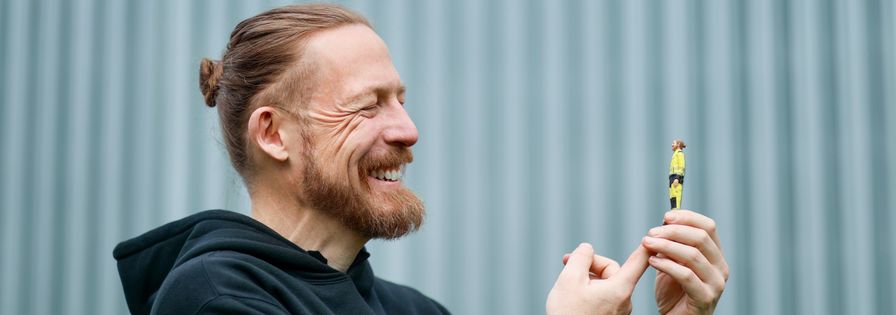 Mitarbeiter zeigt auf Minifigur