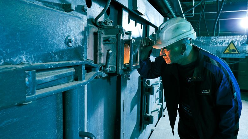 Mitarbeiter schaut in Heizkessel