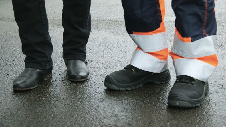 Två par fötter i arbetarkängor och boots