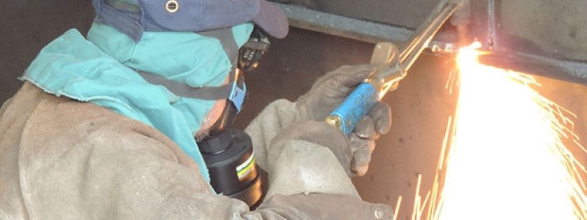 Person schweißt Metall, funken fallen zu Boden