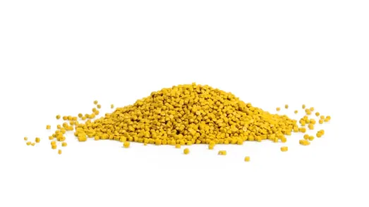Pile of yellow plastic granules on a white background