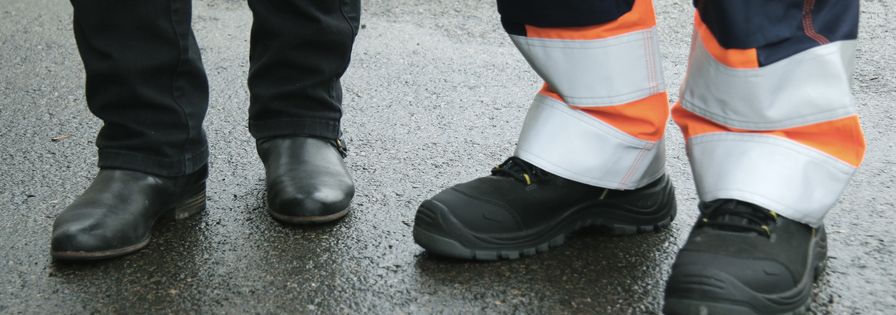 Två par fötter i arbetarkängor och boots
