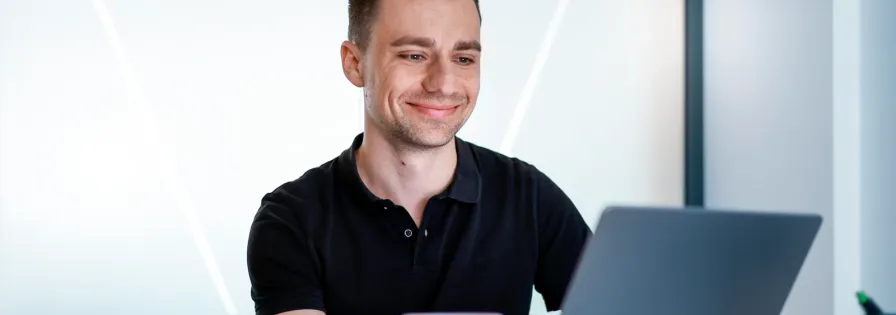 Lächelnder Teilnehmer verfolgt ein Online-Event zur Kreislaufwirtschaft am Laptop