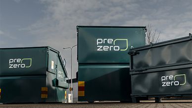 Tre gröna containrar med PreZero-logotyper på, uppställda utomhus