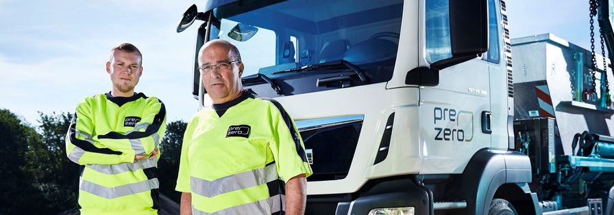 two blue collar worker prezero in front of truck on a plant