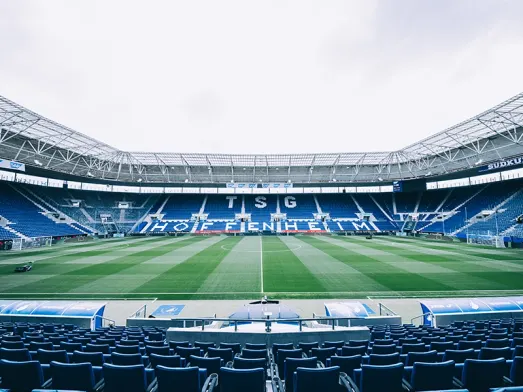 Innenansicht der SNP Arena der TSG Hoffenheim mit blauer Tribüne und Rasenfeld für nachhaltigen Stadionbetrieb