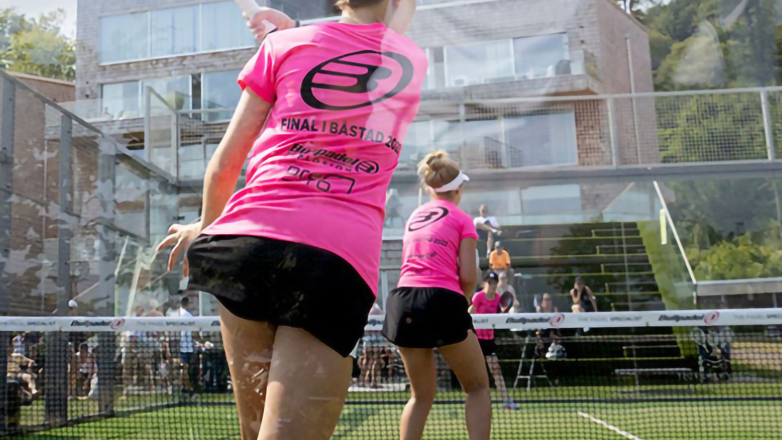 Två tjejer, sedda bakifrån, som spelar padel