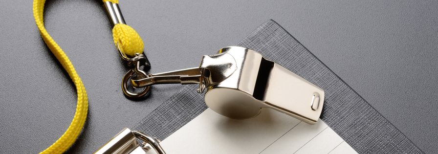 Visselpipa på bord tillsammans med block och penna