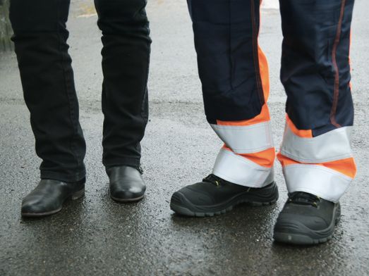 Två par fötter i arbetarkängor och boots