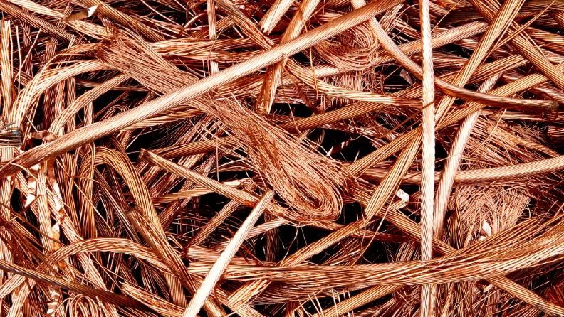 Nahaufnahme von vielen ungeordneten, blanken Kupferdrähten mit rötlichem Metallglanz