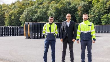 Mitarbeiter vor Tonnenstapel