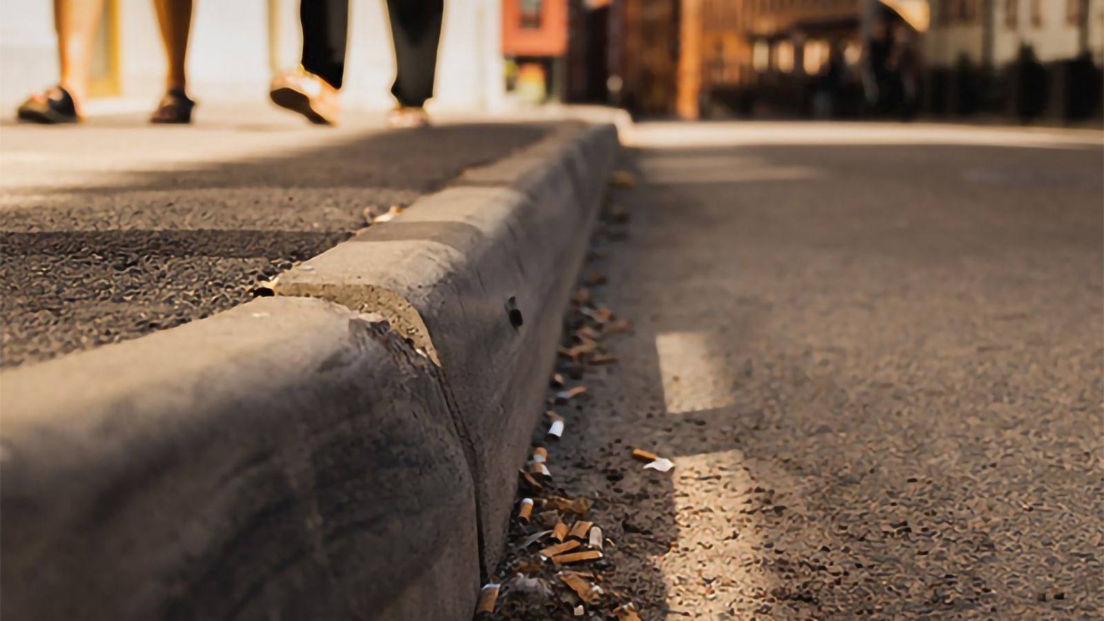 Fimpar och annat skräp längs med en trottoar