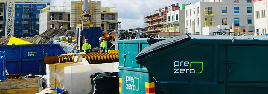 PreZero-containrar på byggplatsen, byggnationer i bakgrunden