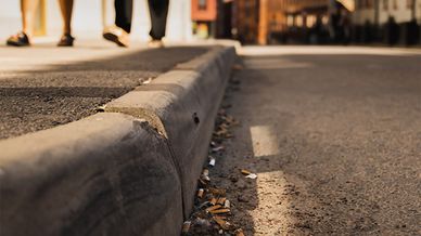 Fimpar och annat skräp längs med en trottoar