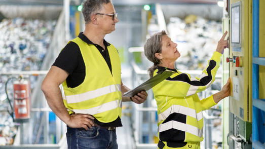 Mann mit Clipboard und Frau gucken auf Screen in Anlage