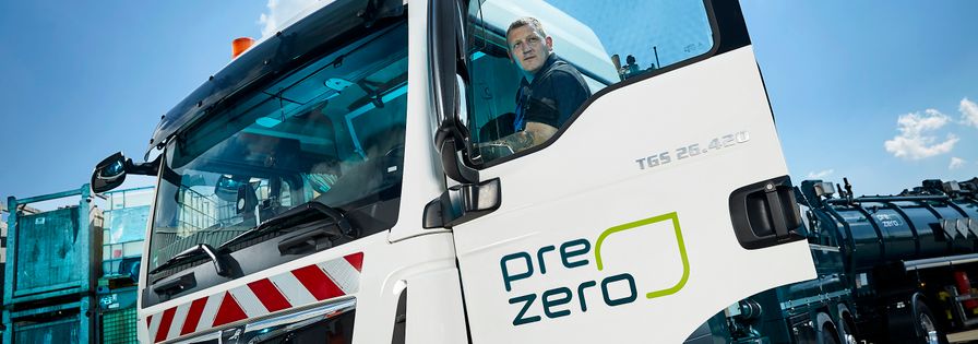 PreZero truck with open door and employee standing on its stairs