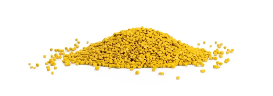 Pile of yellow plastic granules on a white background