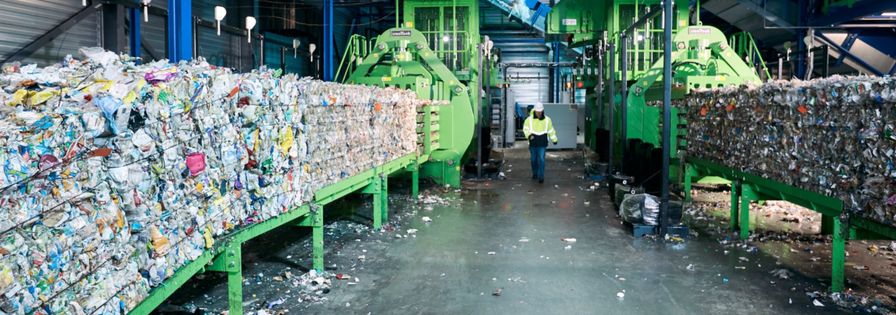 Waste bales at plants and an employee runs between the two plants