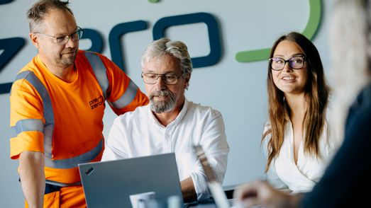 Fyra personer, tjänstemän och miljöarbetare, samarbetar vid dator