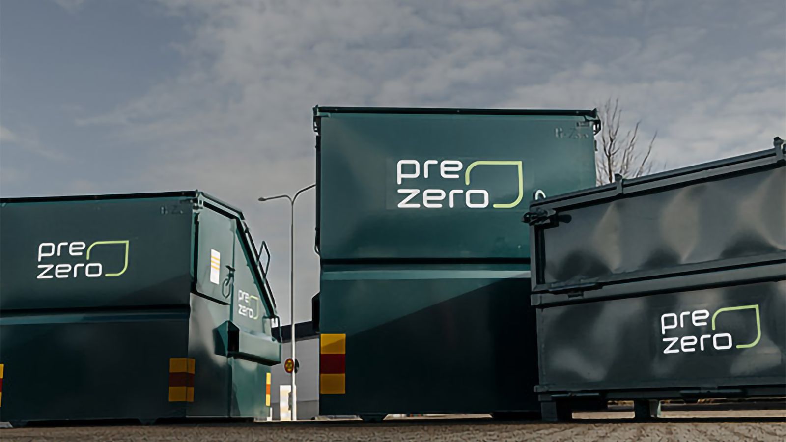 Tre gröna containrar med PreZero-logotyper på, uppställda utomhus