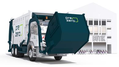 PreZero-bil som lyfter en frontlastarcontainer framför en butik.