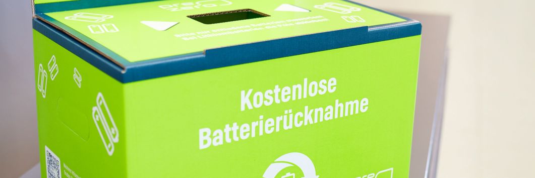 Altbatterien und Akkus können in den Lidl-Filialen über den Einwurfschacht der Wertstoffbox entsorgt werden. Zur besseren Veranschaulichung haben wir den Rücknahmekarton außerhalb der Wertstoffbox platziert.