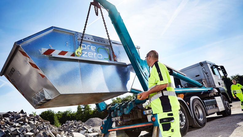 Employee unloads truck with container - stones in the background