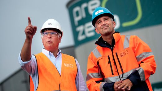 Två PreZero-medarbetare som blickar framåt/uppåt och pekar