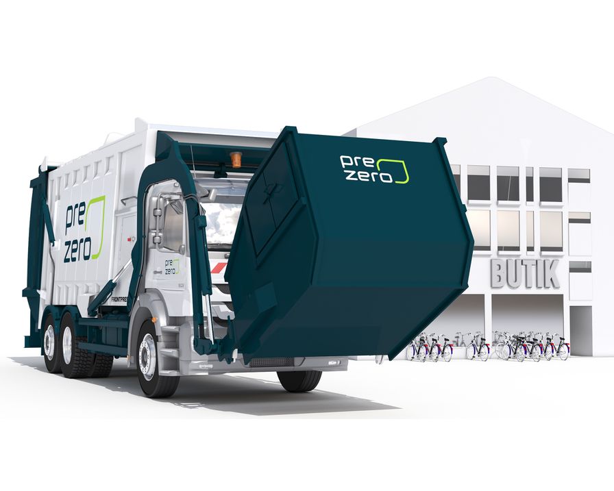 PreZero-bil som lyfter en frontlastarcontainer framför en butik.