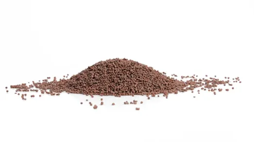 Pile of brown plastic granules on a white background