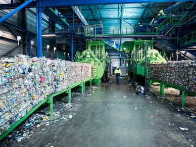 Waste bales at plants and an employee runs between the two plants