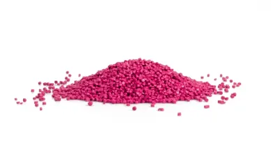 Pile of pink plastic granules on a white background