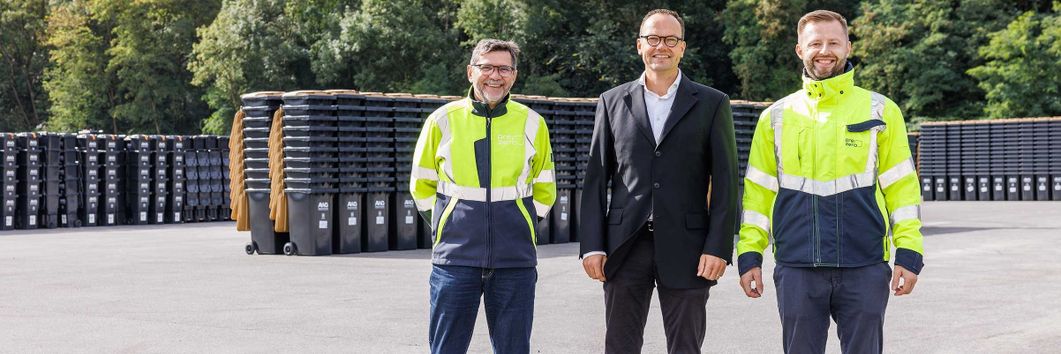 Mitarbeiter vor Tonnenstapel