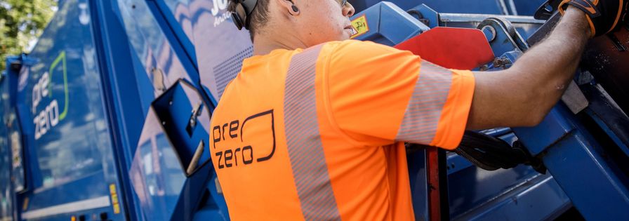 Miljöarbetare som tömmer ett kärl i en baklastare