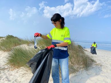 Colaboradora da PreZero Portugal recolha pacote de bolachas antigo da praia do Furadouro, no World Cleanup day
