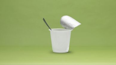 Joghurtbecher auf grünem Grund