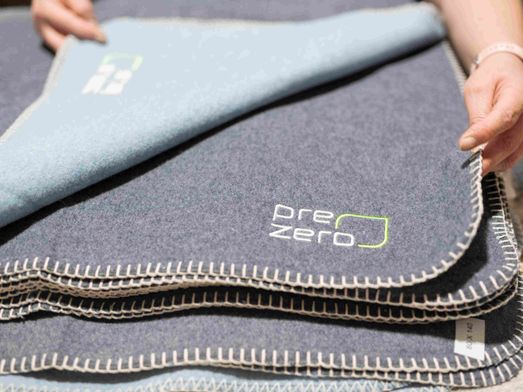 Mantas com logo PreZero, que resultaram do projeto de reciclagem do fardamento antigo da empresa - economia circular